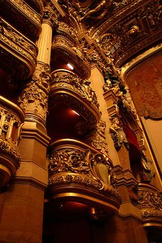 an ornately decorated building with gold paint on the walls and ceiling is lit by lights