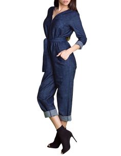 a woman is posing in a blue jumpsuit