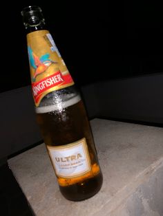 a bottle of beer sitting on top of a stone block