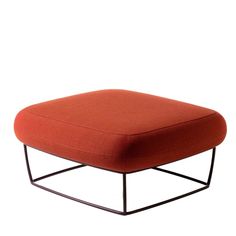 an orange ottoman sitting on top of a metal frame