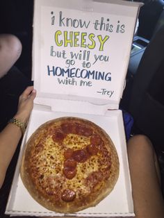 a person holding up a box with a pizza in it's lap and an advertisement on the inside