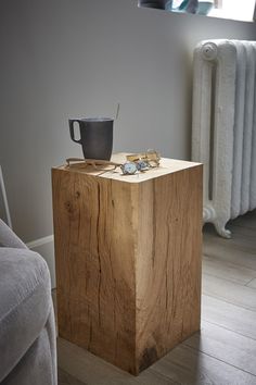 a wooden table with a cup on top of it next to a radiator