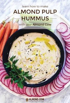 a bowl of hummus with carrots and celery on the side next to some sliced radishes