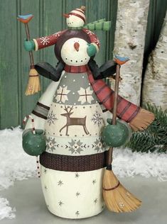 a ceramic snowman with brooms and hat