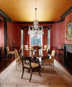 a formal dining room with red walls and chandelier