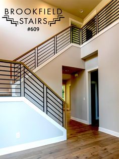 an empty room with stairs and wood flooring