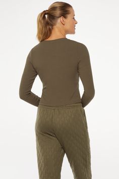 A closet essential with studio-to-street versatility, ready to be dressed up or down, worn layered or on its own, this rib knit top in deep olive green features a fitted long-sleeved silhouette and a flattering scoop neckline. Brand: Marika 87% Rayon/13% Spandex 20" Length (Size M) Rib Knit Scoopneck With Long Sleeves Fitted With Coverstitch Detailing Machine Wash Color: Grape Leaf Fall Long Sleeve Top For Layering With Scoop Neck, Fall Long Sleeve Scoop Neck Top For Layering, Olive Crew Neck Top For Winter, Olive Stretch Tops For Fall, Fall Olive Crew Neck Top, Olive Crew Neck Top For Fall, Olive Long Sleeve Tops For Winter, Olive Long Sleeve Top For Layering, Khaki Tops For Fall Loungewear