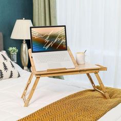 a laptop computer sitting on top of a wooden stand next to a cup of coffee