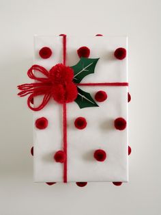 a present wrapped in white and red polka dot paper