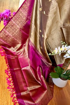 Experience the pure elegance of our handwoven Kanjivaram Silk Saree inspired by banarasi weaves. Crafted in a stunning khaki color, this saree features a deep purple border and grand pallu adorned with traditional motifs. The banarasi weave inspired morning and evening borders have traditional motifs in gold zari. This saree is a must-have for any formal event. Approximate Length 6.5 mtrs (inclusive of blouse length) Approximate Height - 48 - 52" Approximate weight - 1.7 lbs Saree comes with fall, picot and tassels done when applicable. Blouse piece is cut. Kindly Note : The colors you see on your device may vary due to the color reproduction, brightness and resolution of individual devices. If you'd like more clarity before your purchase, please contact our support team. Brown Banarasi Silk Dupatta With Zari Weaving, Brown Dupatta With Traditional Patterns For Wedding, Brown Traditional Wear With Pallu For Ceremonies, Brown Wedding Dupatta With Traditional Patterns, Wedding Brown Dupatta With Traditional Patterns, Elegant Brown Dupatta With Zari Weaving, Brown Handloom Dupatta For Wedding, Brown Saree With Traditional Patterns For Wedding, Brown Saree With Zari Weaving For Puja