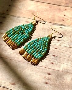 "Beautiful handmade earrings with a combination of two-color, Turquoise and gold color glass beads hanging from the gold plated ear wires Very chic and elegant.  Unique style. **Earrings are measured 2 3/4\" from ear wires to the end of the fringes." Handmade Turquoise Earrings For Festive Occasions, Green Drop Earrings With Gold Beads, Green Gold Beaded Drop Earrings, Handmade Festive Turquoise Earrings, Festive Handmade Turquoise Earrings, Festive Turquoise Beaded Earrings, Turquoise Dangling Bead Drop Earrings, Turquoise Czech Glass Dangling Beads Earrings, Turquoise Dangling Beaded Earrings