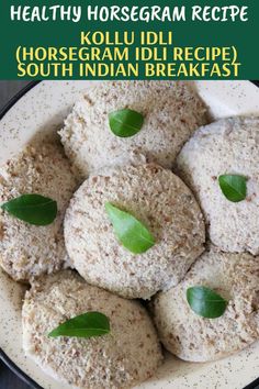 a white plate topped with cookies covered in powdered sugar and green leafy leaves