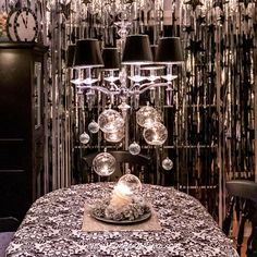 a dining room table with a fancy chandelier hanging from it's ceiling