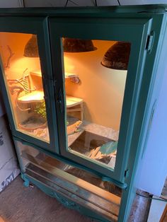 a green cabinet with two lights inside of it