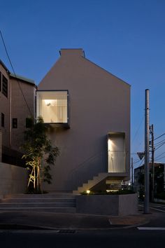 an apartment building with stairs leading up to the upper floor and second story windows at night