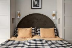 a bed with black and white checkered bedspread, two lamps on either side