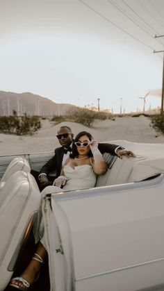 a bride and groom sitting in the back of a white convertible car on their wedding day