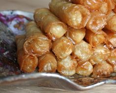 a pile of fried food sitting on top of a wooden table next to a spoon