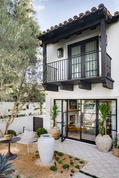 a white house with black balconies and windows