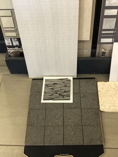 a black and white tile floor in front of a building with an open window on the side