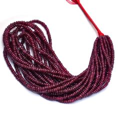 purple seed beads with red string on white background