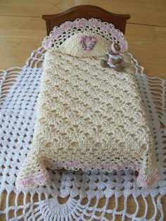 a crocheted baby blanket on top of a wooden bed