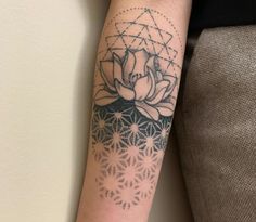 a woman's arm with a tattoo on it that has a flower in the center