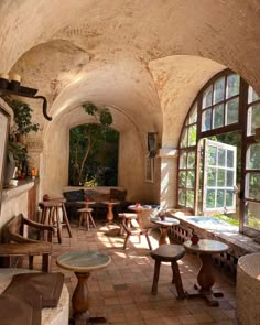 an arched room with several tables and chairs