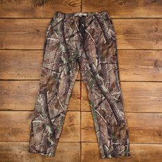 a pair of camouflage pants sitting on top of a wooden floor