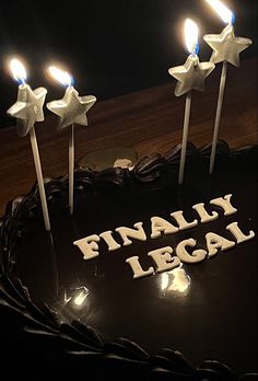 a birthday cake with five candles on it and the words finally legal spelled in white