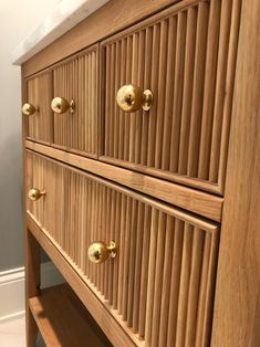 a wooden dresser with brass knobs and drawers