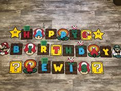 the words happy birthday are spelled with mario and luigi's letters on a wood floor