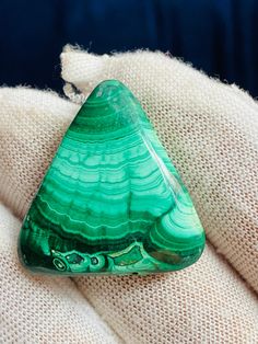 a piece of green glass sitting on top of a white cloth