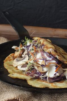 a black plate topped with food on top of a table