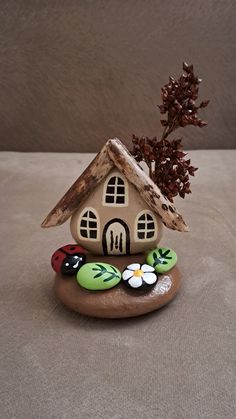 a small house sitting on top of a rock next to a leafy tree branch