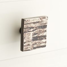 a close up of a wooden door handle on a white cabinet with woodgrain