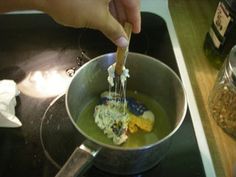 a person stirring something in a pot on the stove