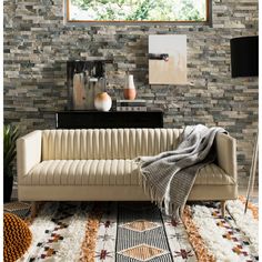 a living room scene with focus on the couch and rugs that are in front of the window