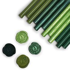 green wax stamping sticks and buttons on white background