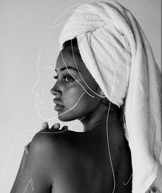 a black and white photo of a woman with a towel on her head looking to the side