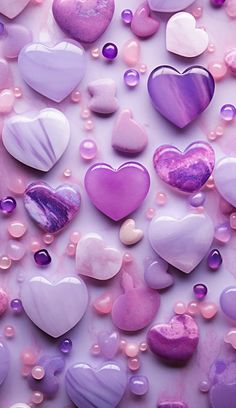 purple and white heart shaped candies on a pink background