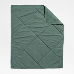 the green quilted blanket is folded up