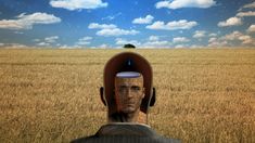 an image of a man in a field with his head turned to look like he is looking into the distance