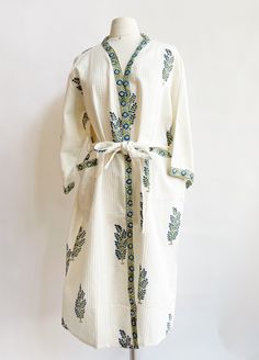 Snuggle into luxury with this unique Waffle Green & Blue Flower Bathrobe. Crafted with block printing and veggie dye, this one-of-a-kind waffle fabric cotton robe is sure to be a cozy favorite. Plus, it's locally made in India, so you know it's the real deal! Wrap yourself in the ultimate comfort. Two pockets on each side to keep your night time goodies. One size fits all Length 46" Width 27" Machine wash cold and hang to dry. Green Bath Robes, Bath Robe Fabric, Night Robe Cotton, Long Quilted Robe, Cloud Patterned Robe, Blue Waffle Robe, Traditional Cotton Home Robe, Traditional Cotton Robe For Home, Spring Cream Cotton Robe