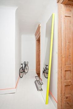 an empty room with two bikes parked in the doorway and one bike leaning against the wall