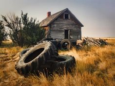 an old house with two tires in front of it