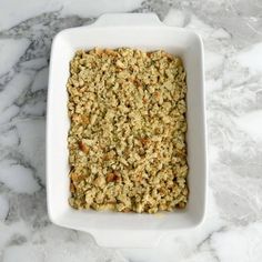 a white dish filled with food on top of a marble counter