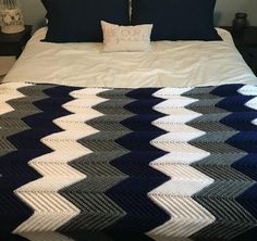 a bed with a blue and white blanket on top of it