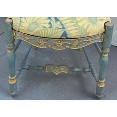 an ornately painted stool with gold trimmings and blue paint on the seat