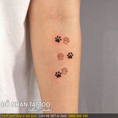 a person with a tattoo on their arm that has three dogs paw prints on it